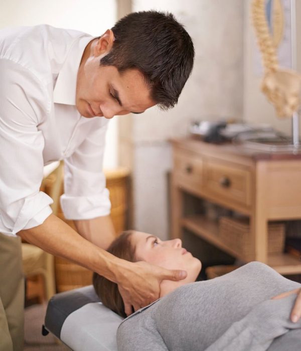 A chiropractor adjusting his patient's neck